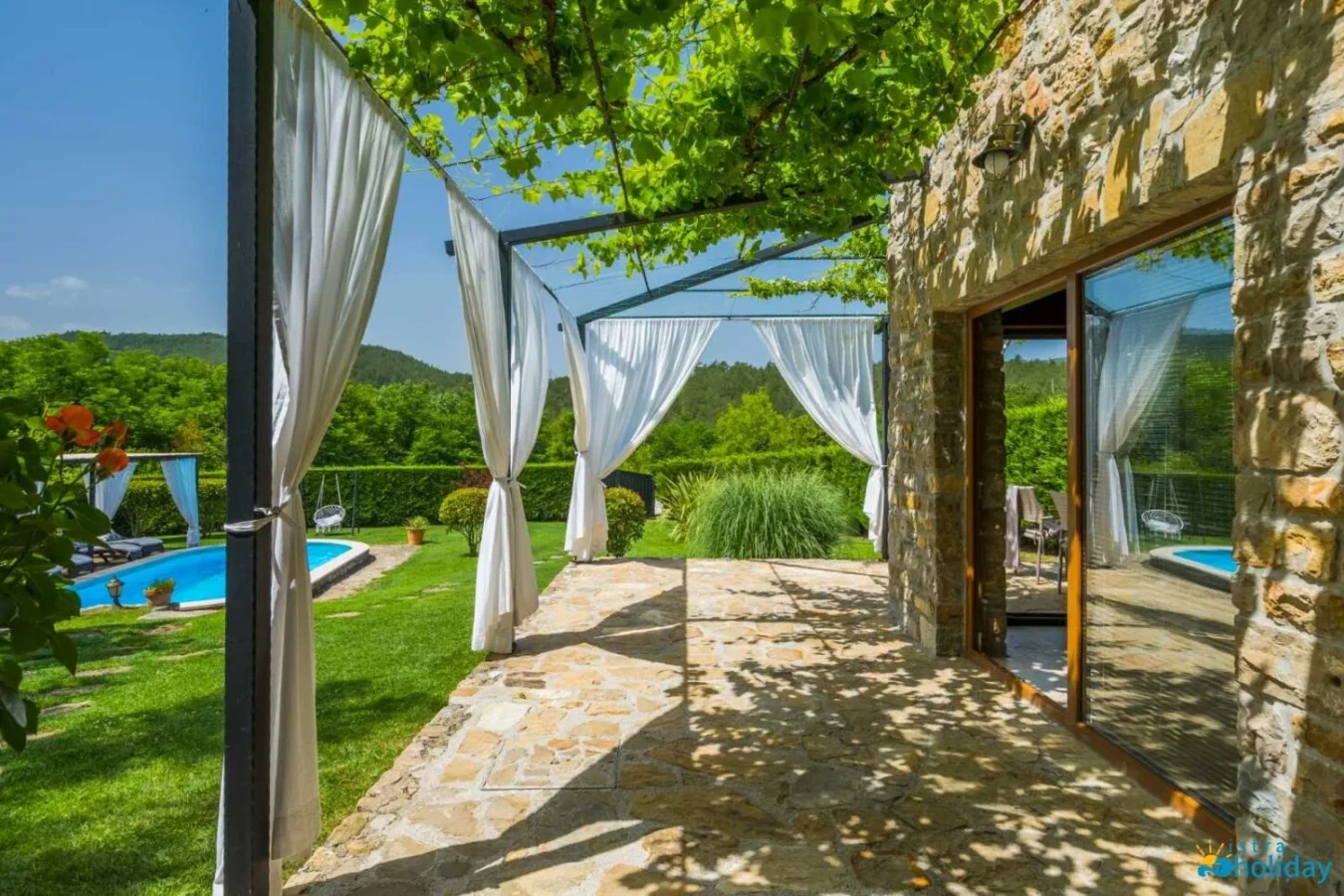 Stone patio with pool and garden view