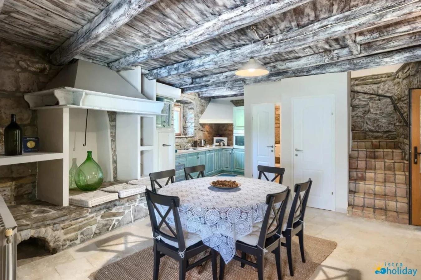 Rustic kitchen with wooden beams and dining table.