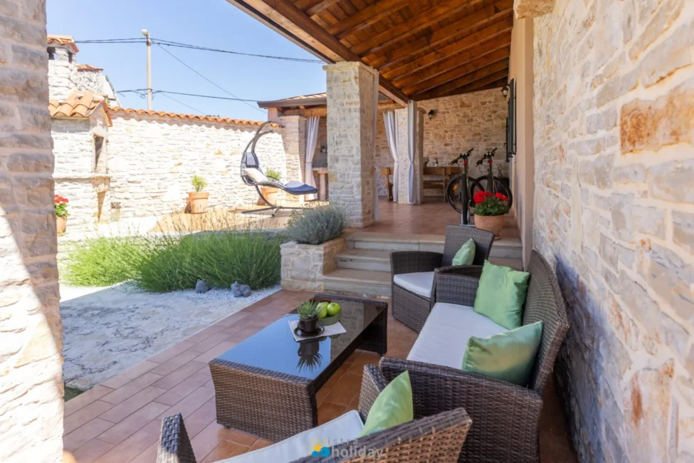 Stone patio with wicker furniture and garden