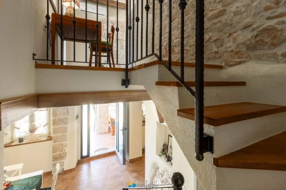 Rustic interior with wooden staircase and stone walls