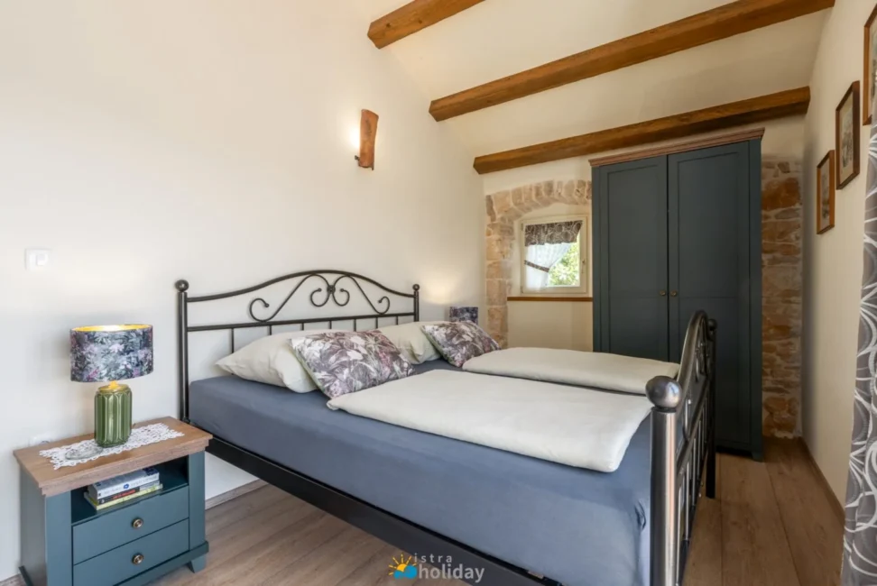 Cozy rustic bedroom with wooden beams and metal bed