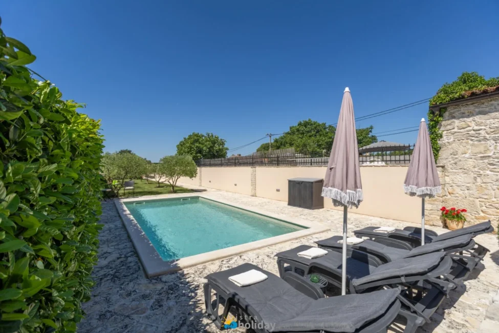 Private outdoor pool with loungers and umbrellas