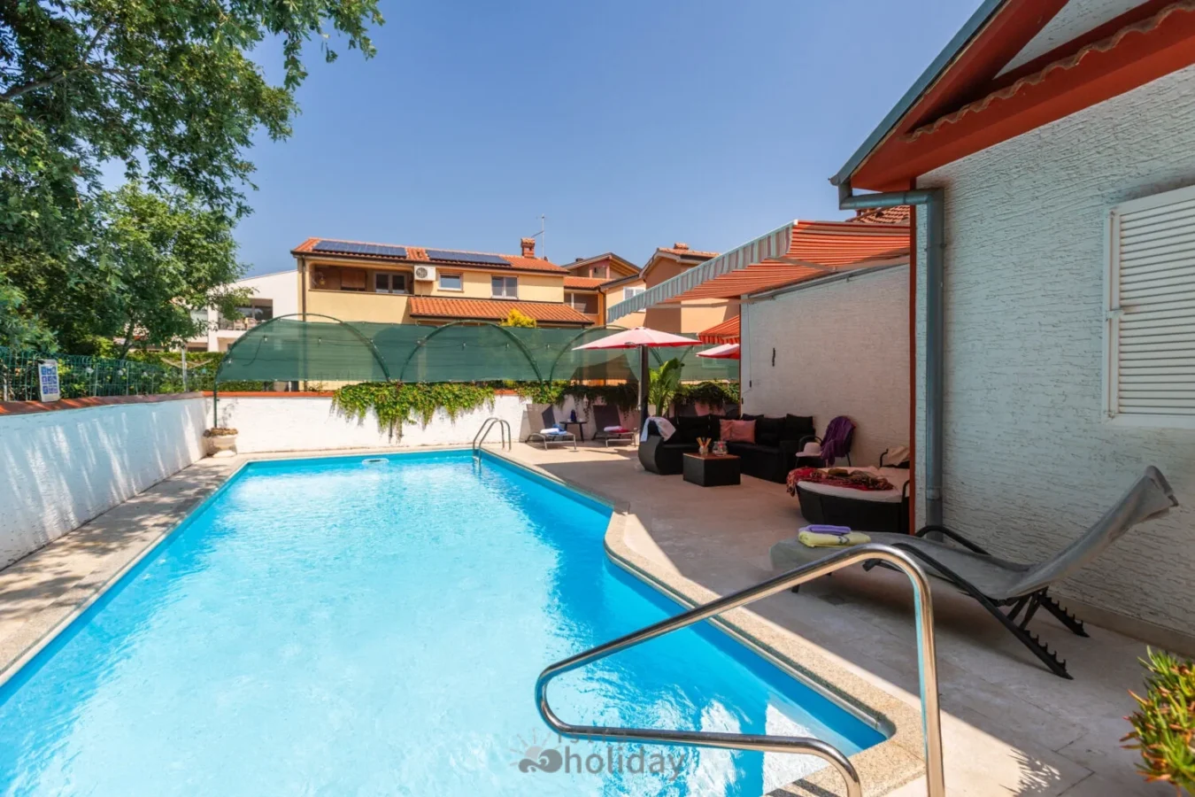 Outdoor pool with sunbeds and umbrellas.