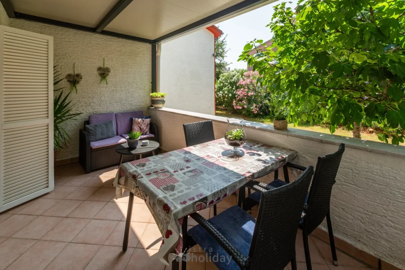 Cozy patio with plants and table setting.