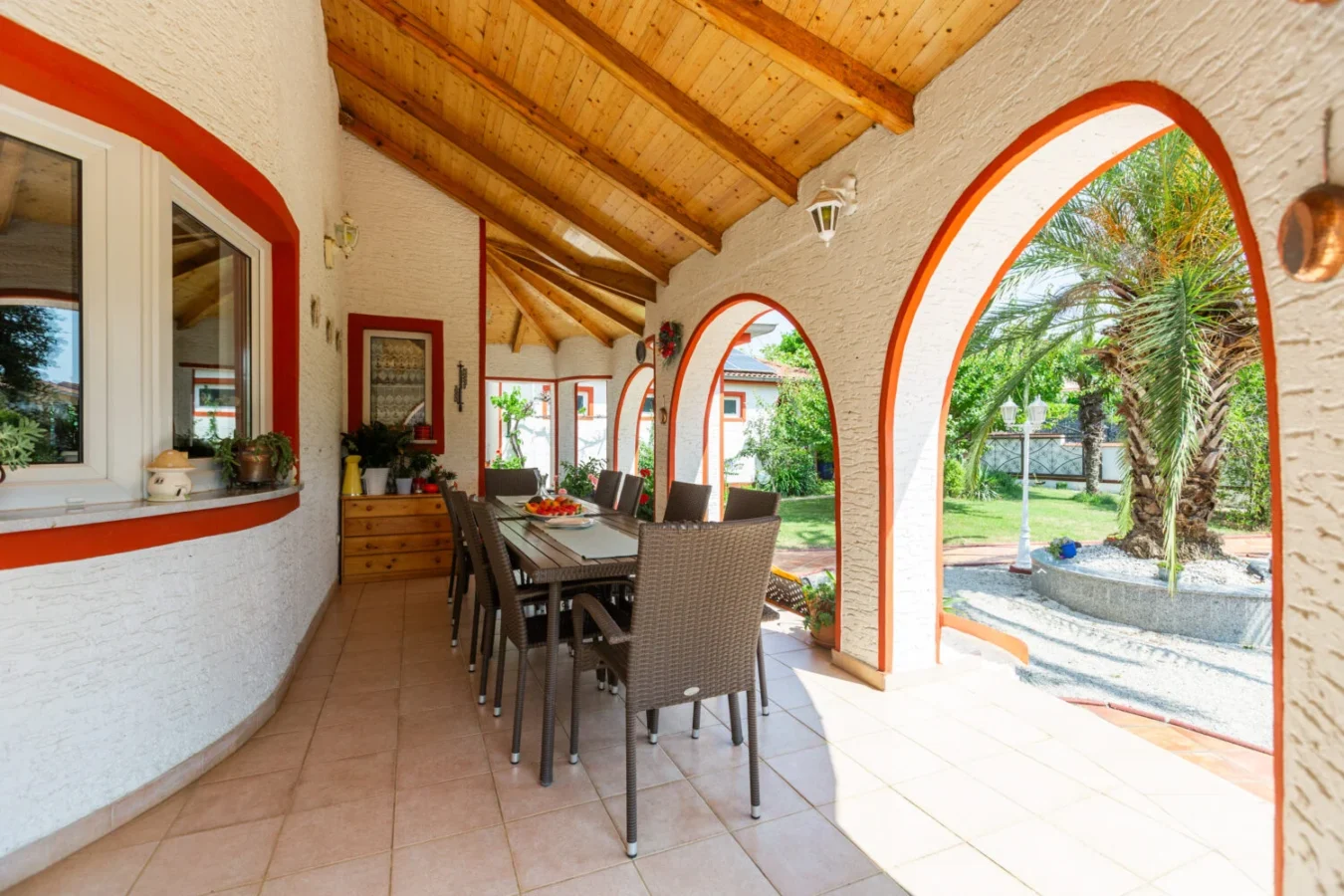 Outdoor patio with dining area and arched openings.