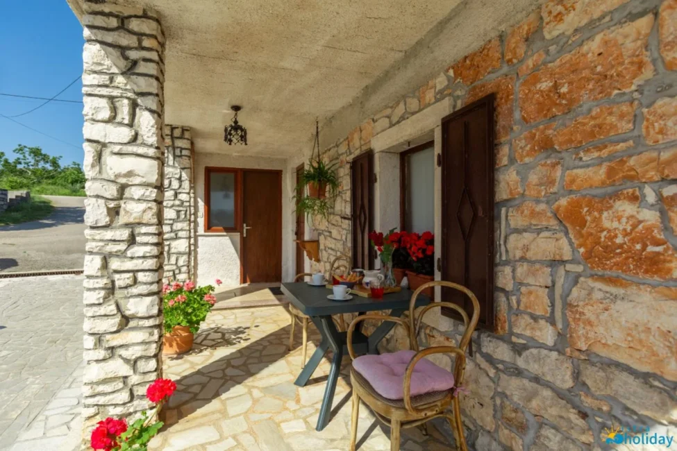 Cozy stone porch with table and flowers