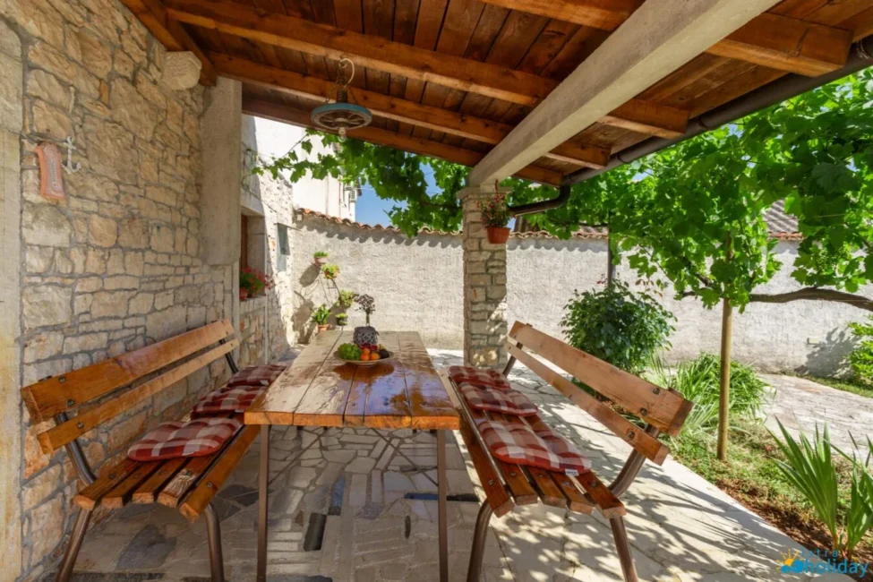 Outdoor patio with wooden table and benches.