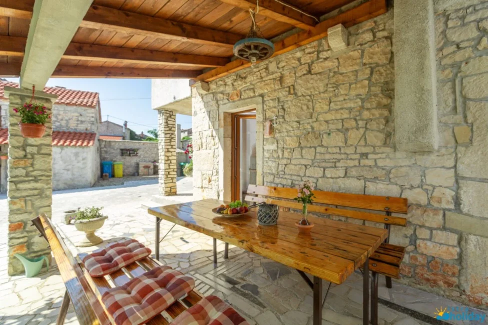Rustic outdoor patio with wooden table and benches.