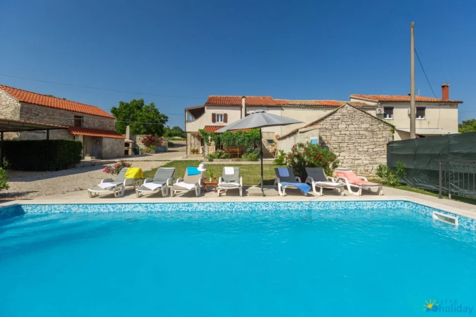 Stone house with pool and lounge chairs