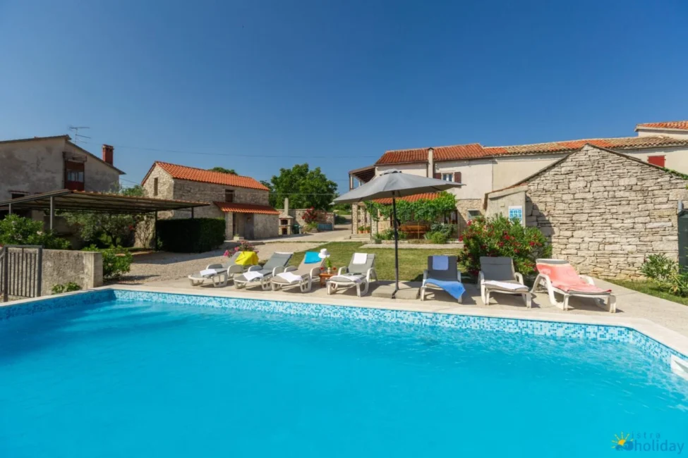 Charming rustic villa with pool and sun loungers.