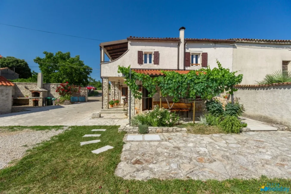 Stone house with garden under blue sky