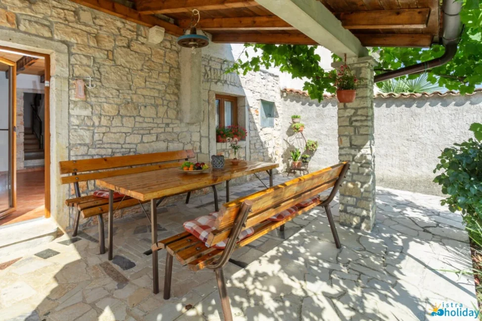 Rustic outdoor dining area with wooden benches and table.