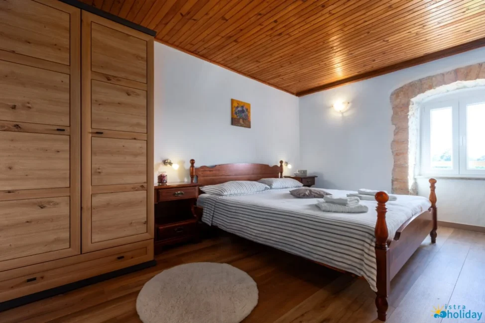 Cozy bedroom with wooden furniture and striped bedding.