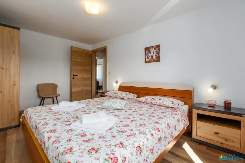 Cozy bedroom with floral bedding and wooden furniture.