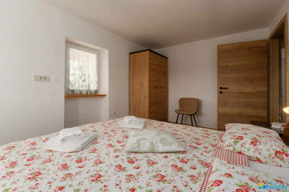 Cozy bedroom with floral bedspread, wooden furniture