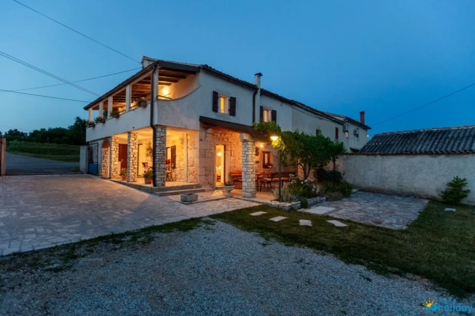 Charming stone house at dusk with warm lighting.