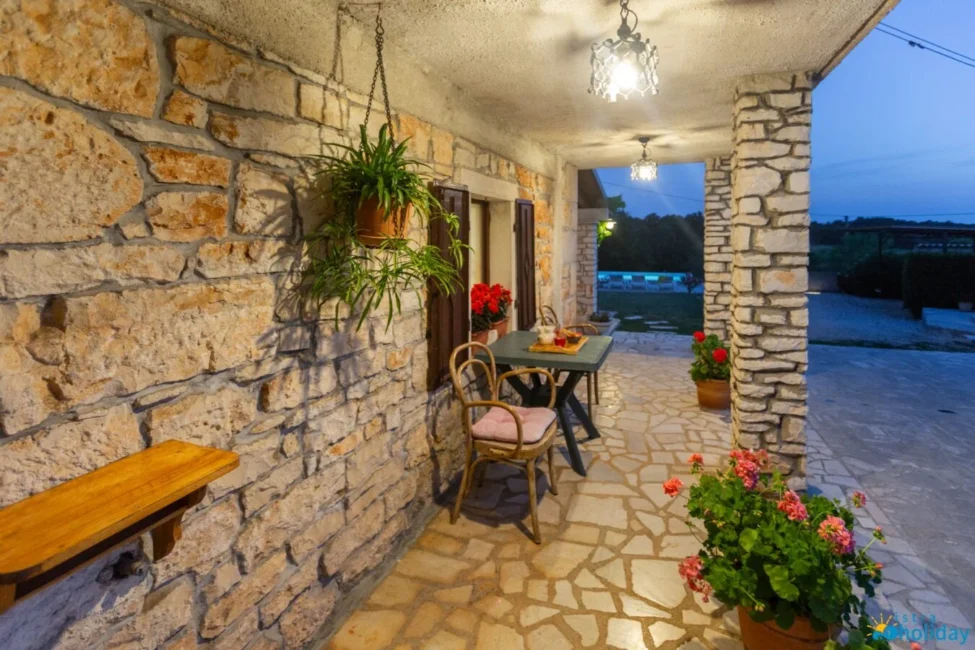 Cozy stone patio with plants and evening lighting
