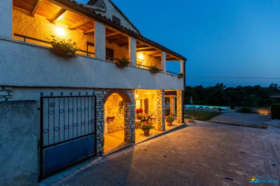 Charming villa with pool at dusk, warm lighting