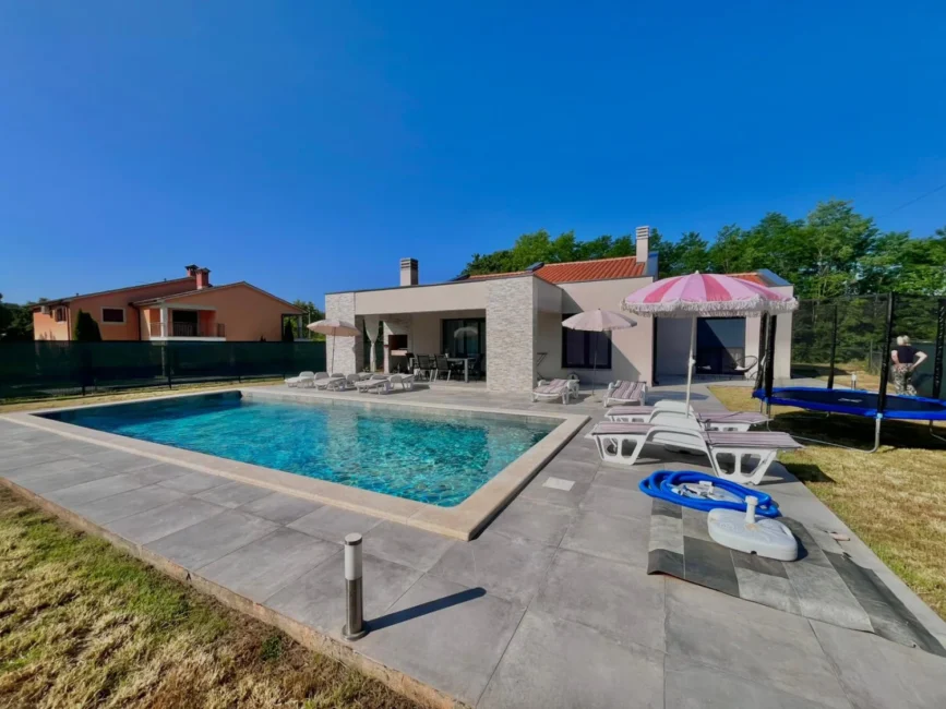 Modern house with backyard swimming pool and lounge chairs